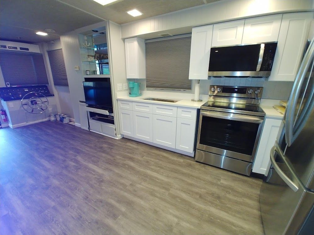 A kitchen with stainless steel appliances and white cabinets.