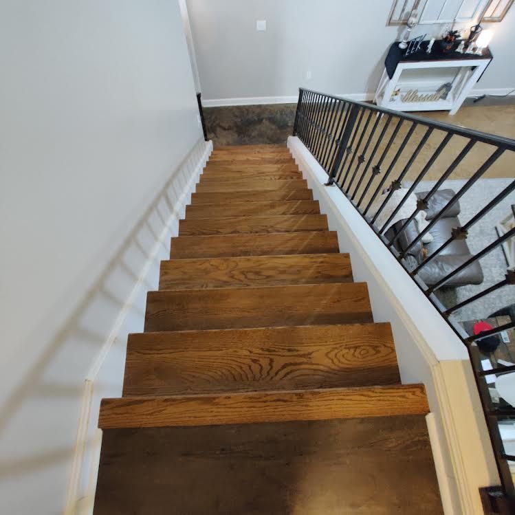 A set of wooden stairs with a metal railing