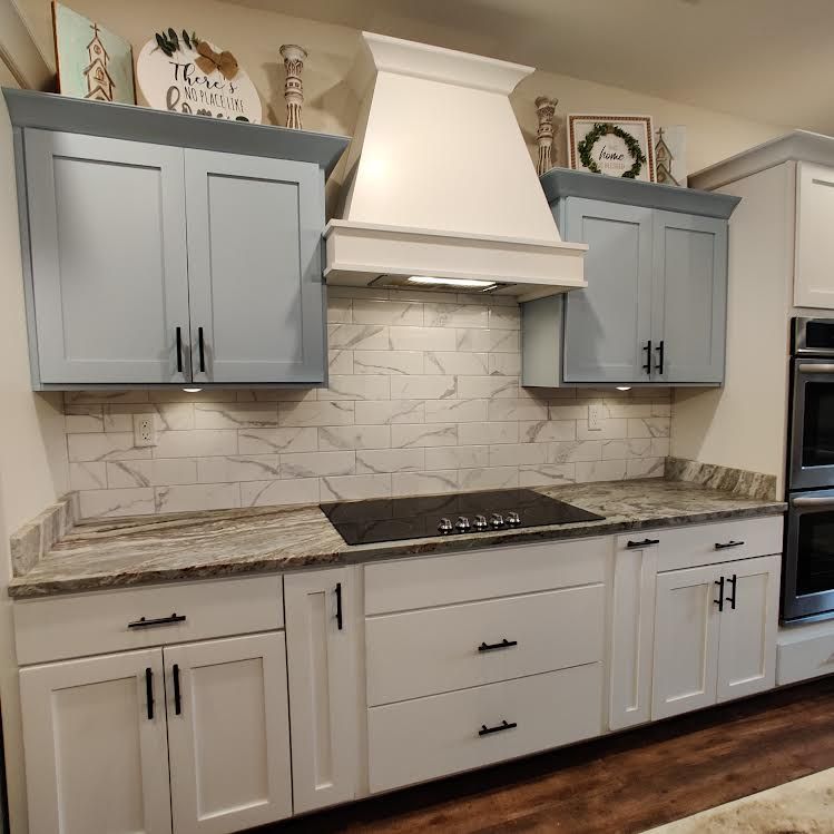 A kitchen with white cabinets and a stove top oven