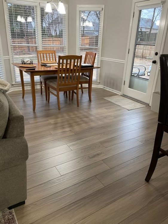 A dining room with a table and chairs and a couch.