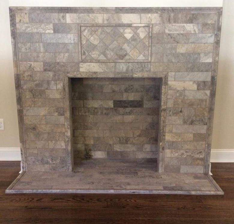 A fireplace made of bricks is sitting on a wooden floor in a living room.