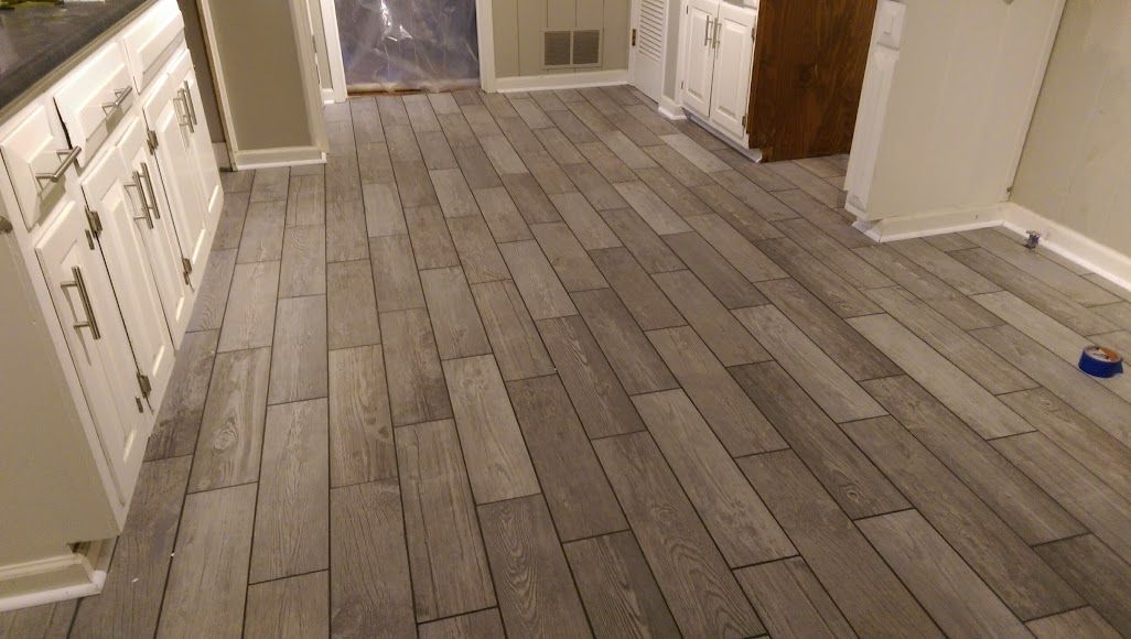A kitchen with a wooden floor and white cabinets.