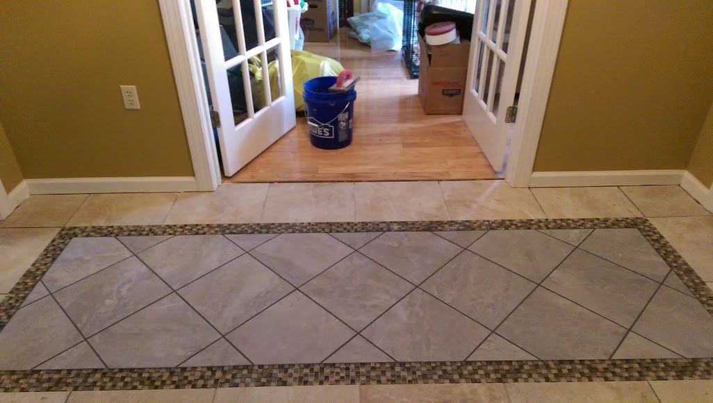 A hallway with a tiled floor and a bucket of pepsi on the floor