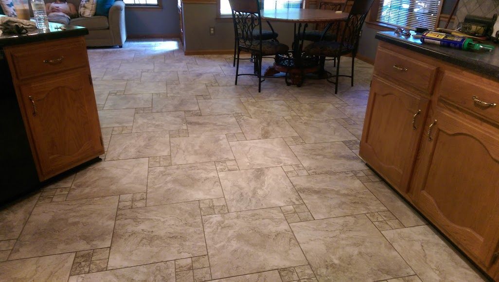 A kitchen with a table and chairs and a tiled floor.