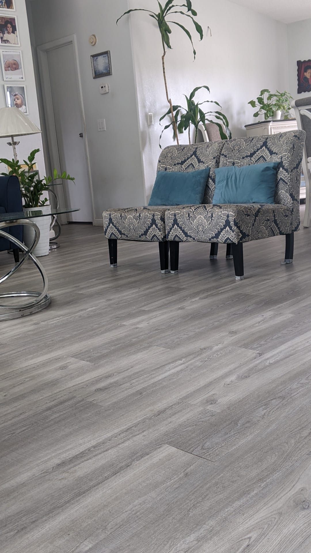 A living room with two chairs and two ottomans on the floor.