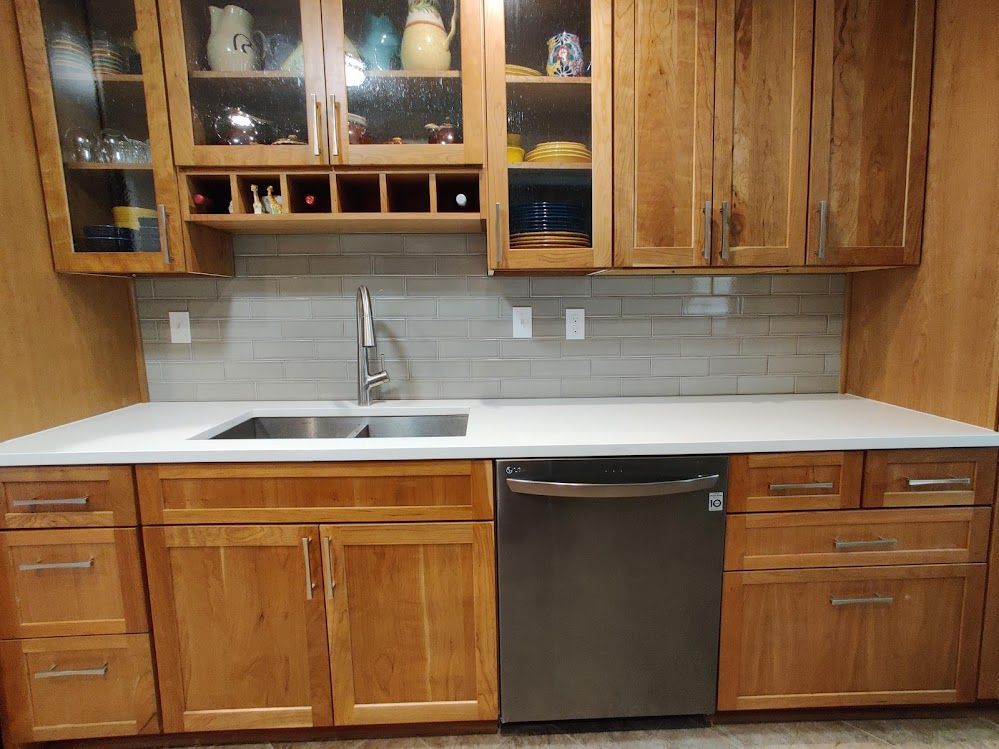 A kitchen with wooden cabinets and a stainless steel dishwasher