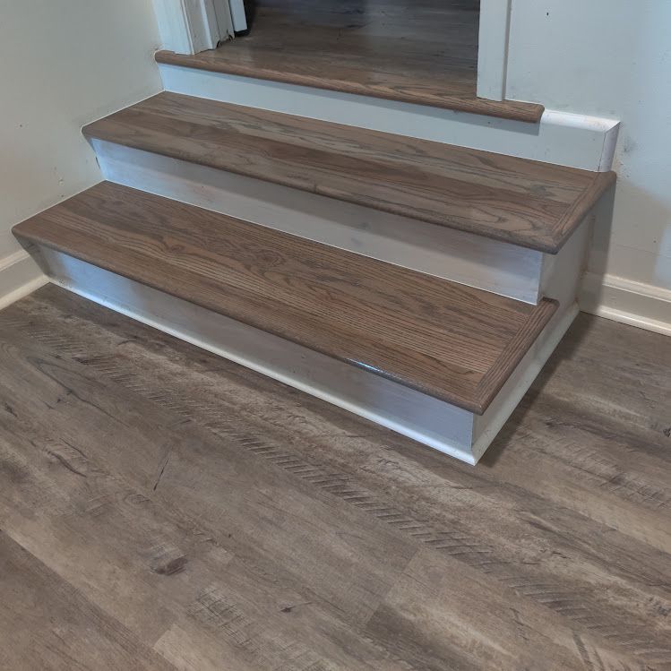 A set of wooden stairs sitting on top of a wooden floor.