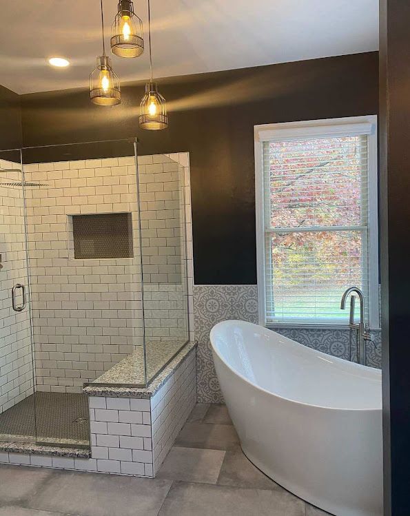 A bathroom with a tub , shower , and window.