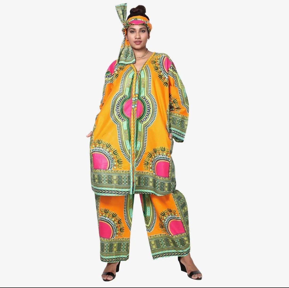 Woman wearing matching orange African print top, pants, and head wrap.