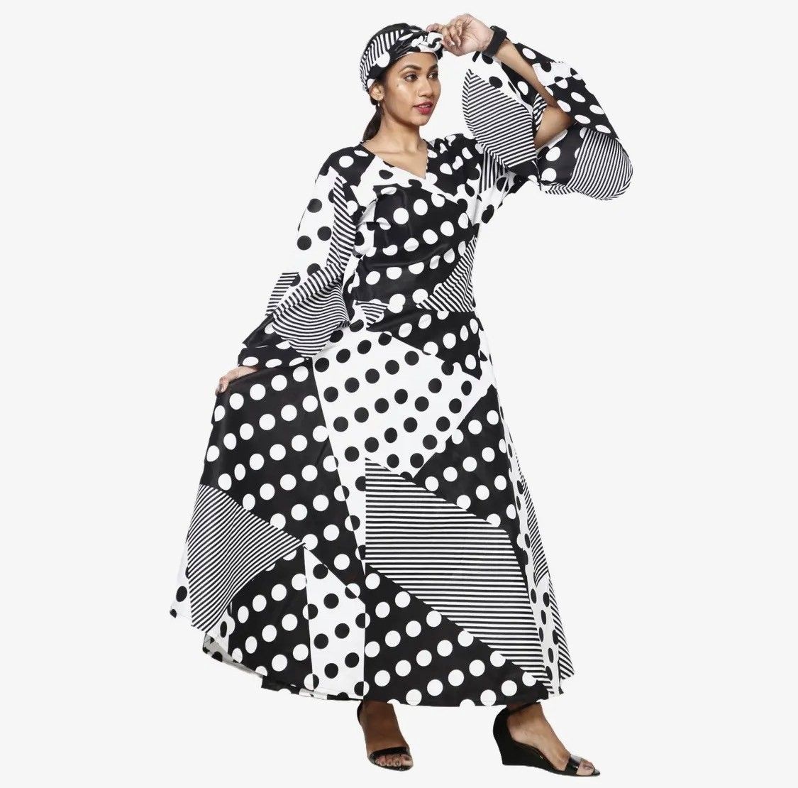 Woman wearing a black and white polka dot and striped dress and matching headwrap.