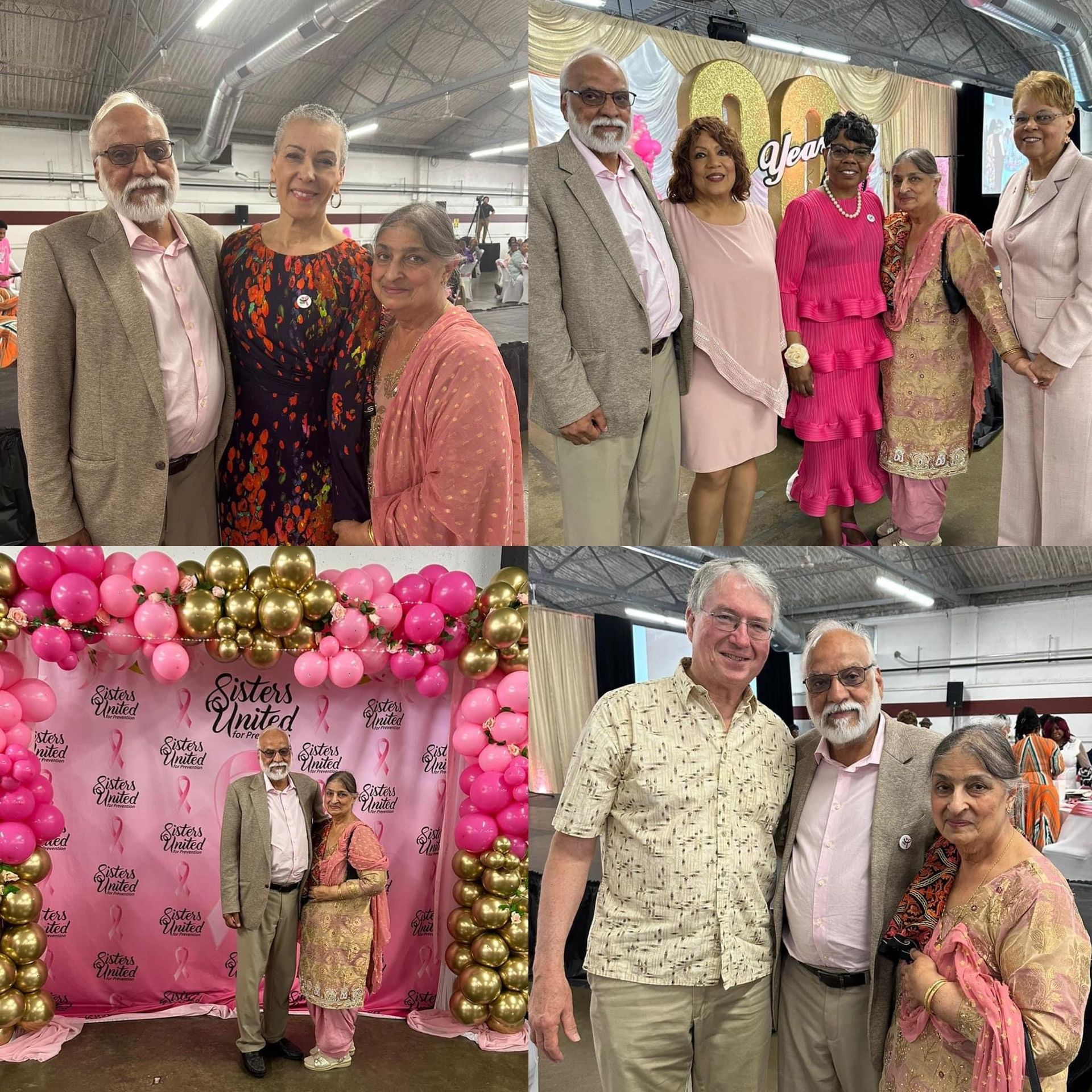 A group of people are posing for a picture in front of a pink wall with balloons.