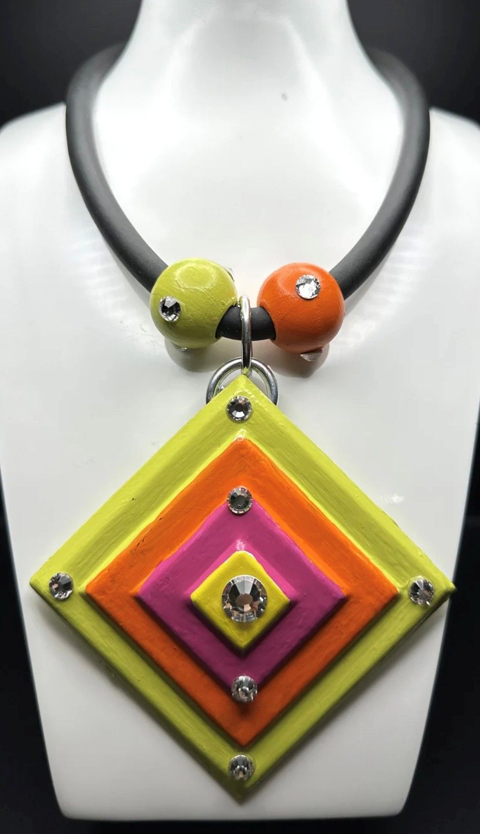 A colorful necklace is on a mannequin