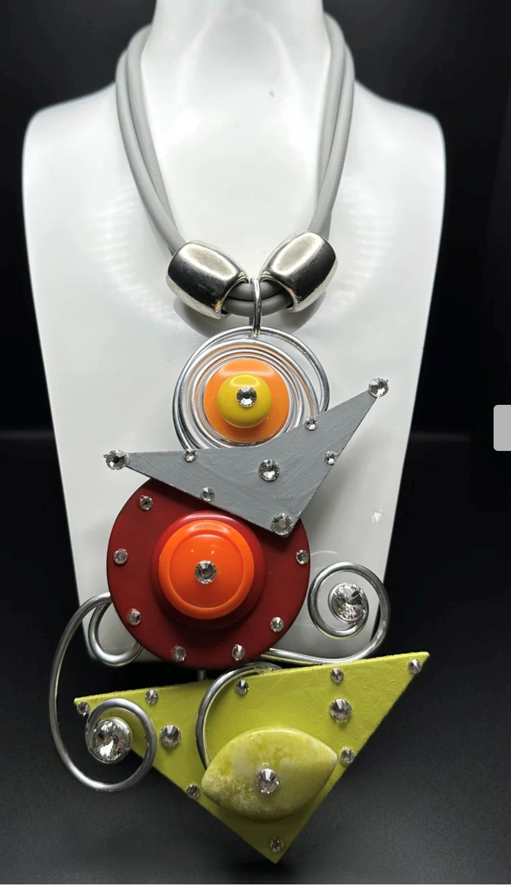 A necklace is on a mannequin with a geometric design