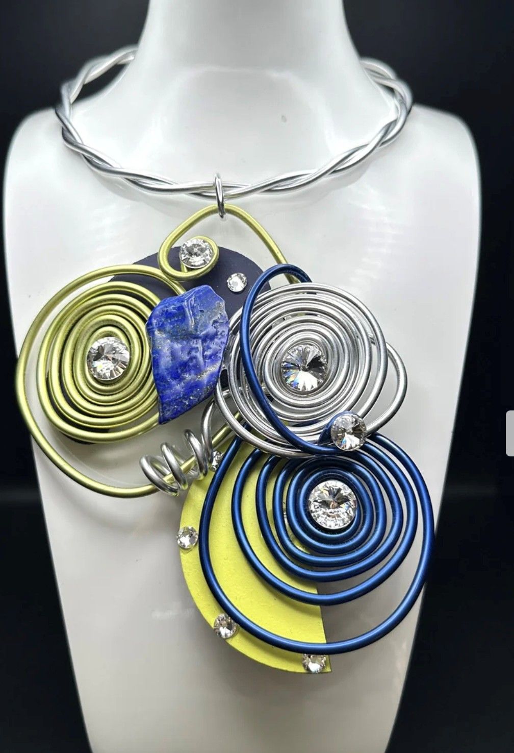 A blue and yellow necklace is on a mannequin