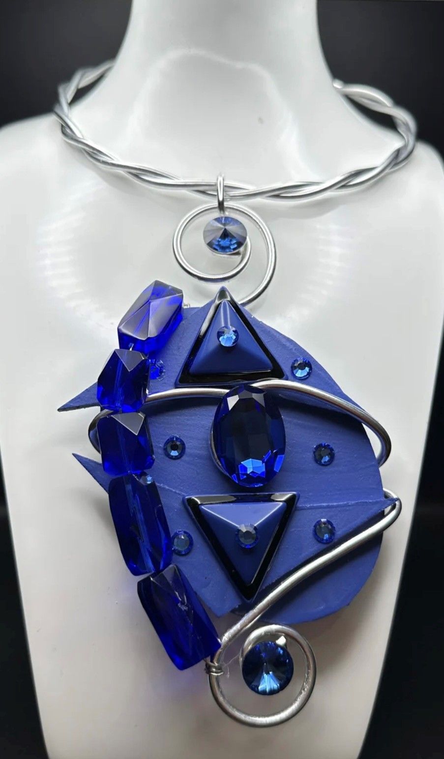 A necklace with blue beads is on a mannequin