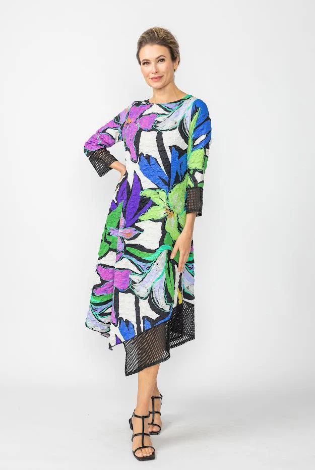 A woman is wearing a colorful dress and sandals