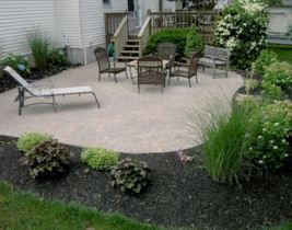 Patio with outdoor furniture surrounded by landscaping and garden beds.