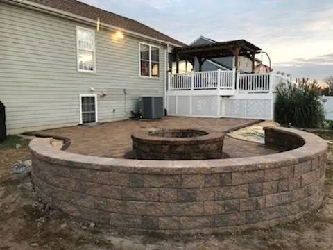 Aerial view of a river winding through a dense evergreen forest. Dark blue water, vibrant green trees.