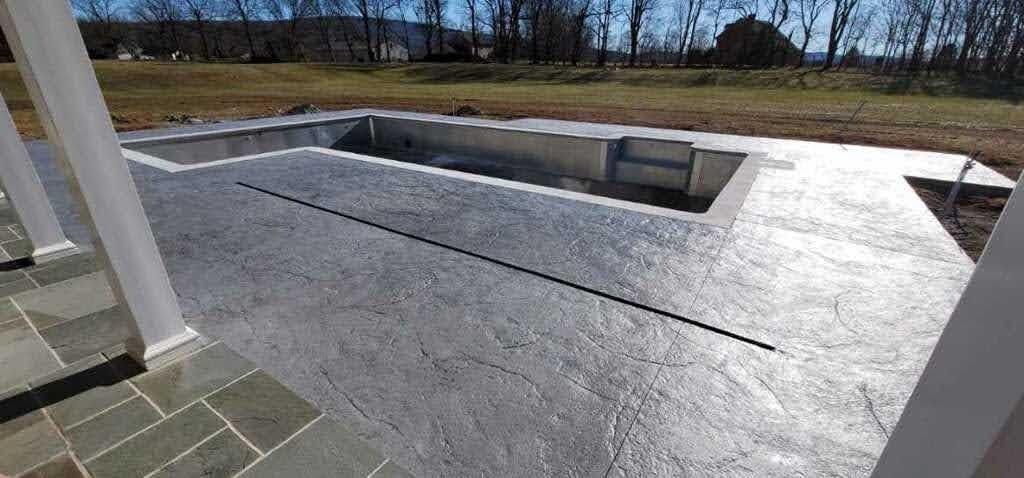 Concrete patio with a pool under construction.