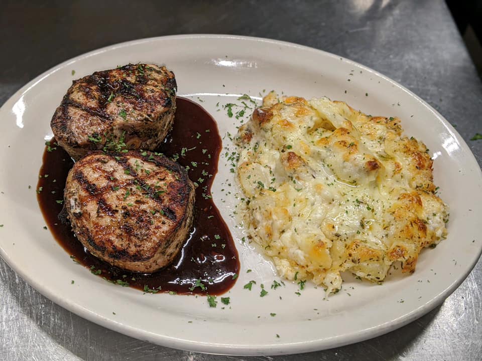 A plate of food with meat and mashed potatoes on a table.