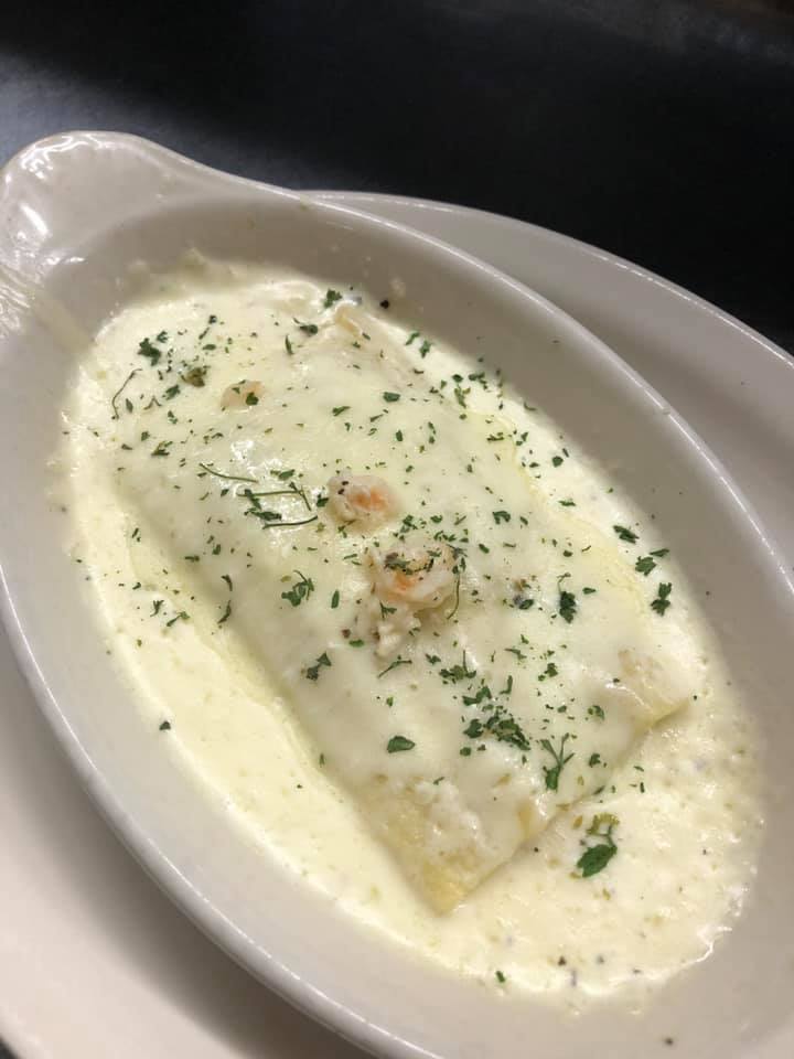 A white plate topped with a casserole dish of food.