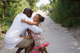 Father hugging his little girls