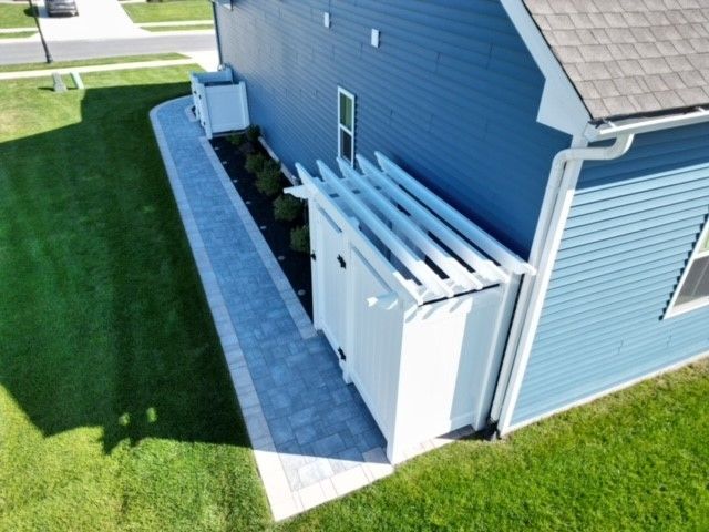 A blue house with a white pergola on the side