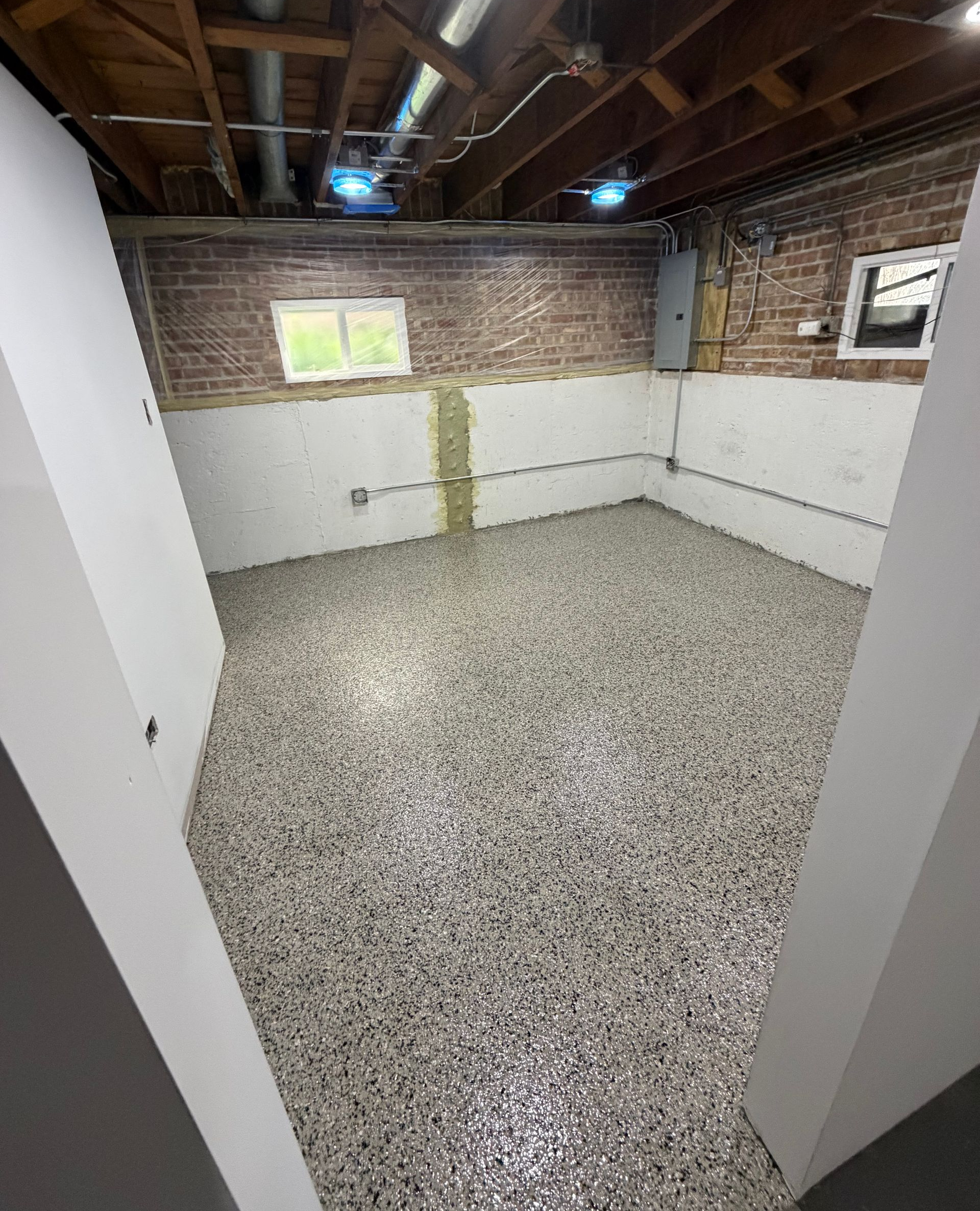 Basement epoxy flooring installation in Chicago with decorative flake concrete coating