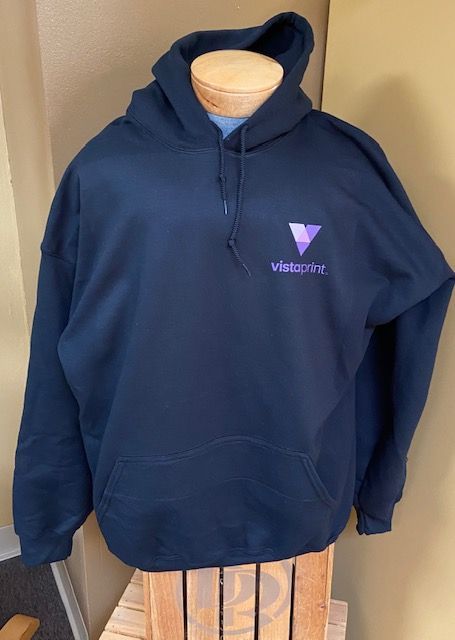 A blue hoodie is sitting on a wooden crate on a mannequin.