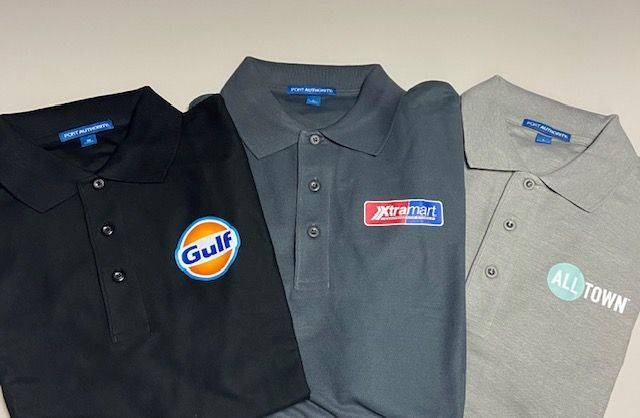 Three polo shirts with logos on them including gulf and alltown