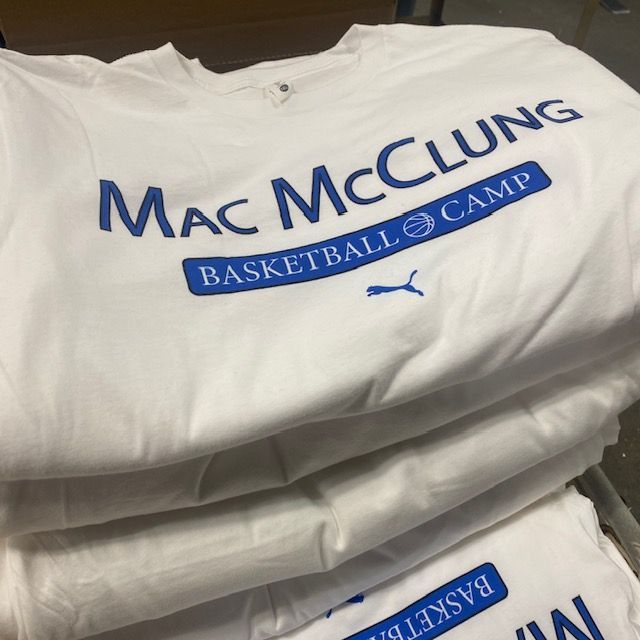 A stack of mac mcclung basketball camp shirts