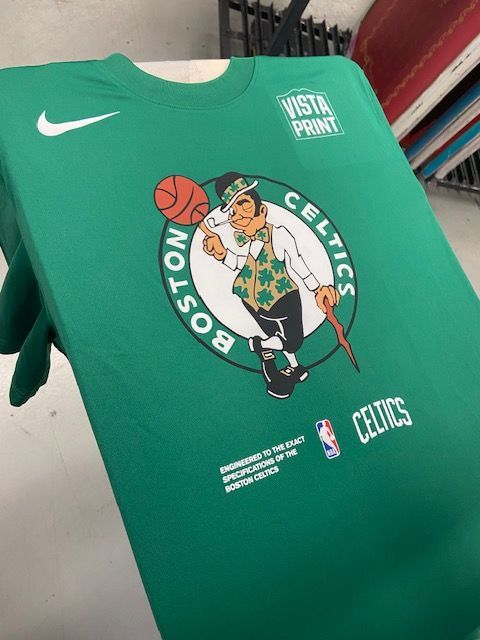 A person is holding a green boston celtics t-shirt