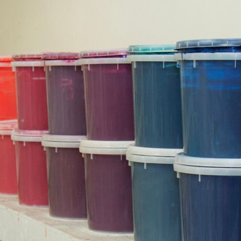 Buckets of different colors are lined up on a shelf