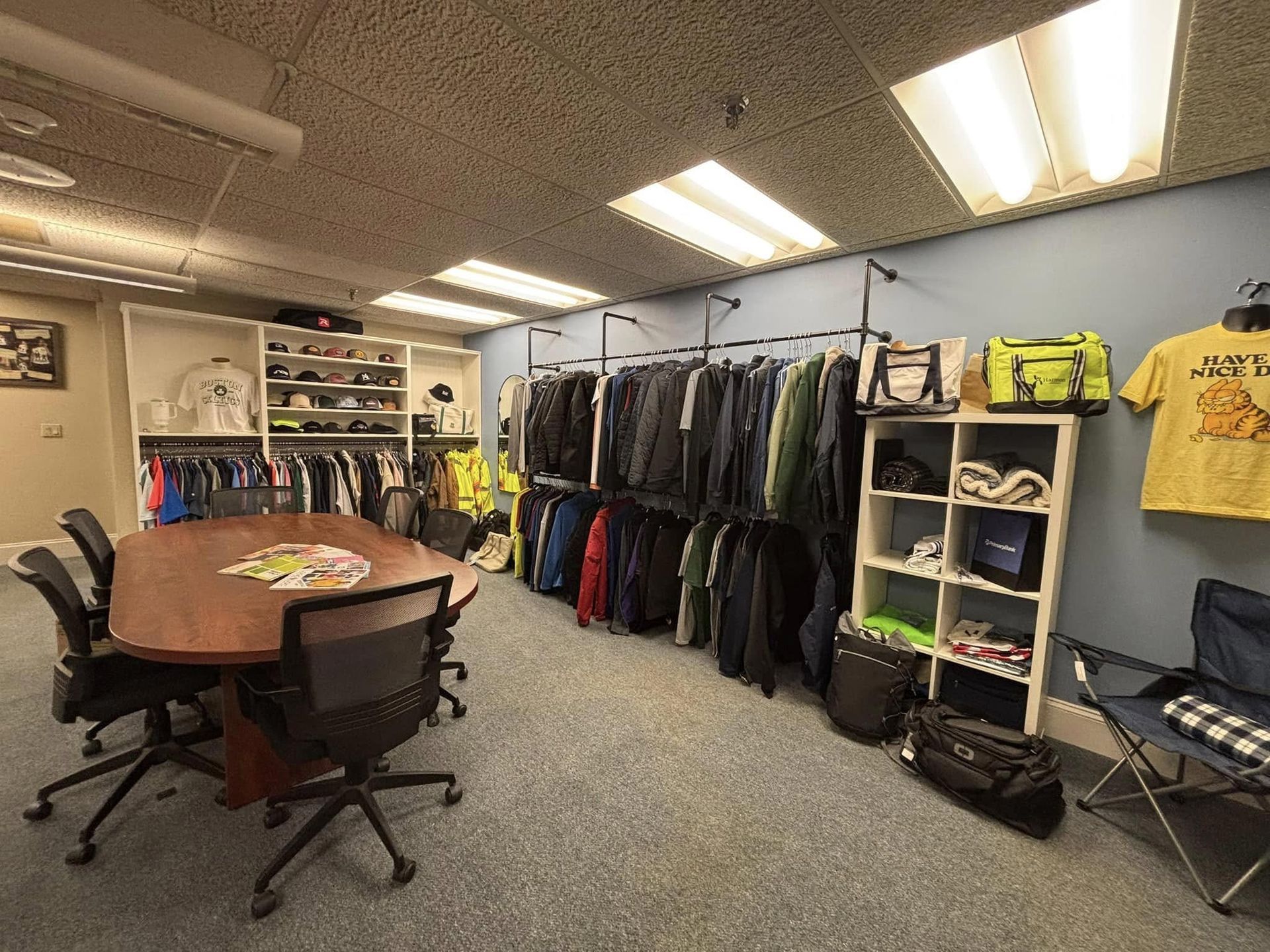 A room with a table and chairs and clothes hanging on the wall