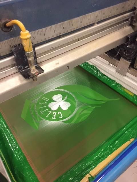 A screen printing machine with a celtics logo on it
