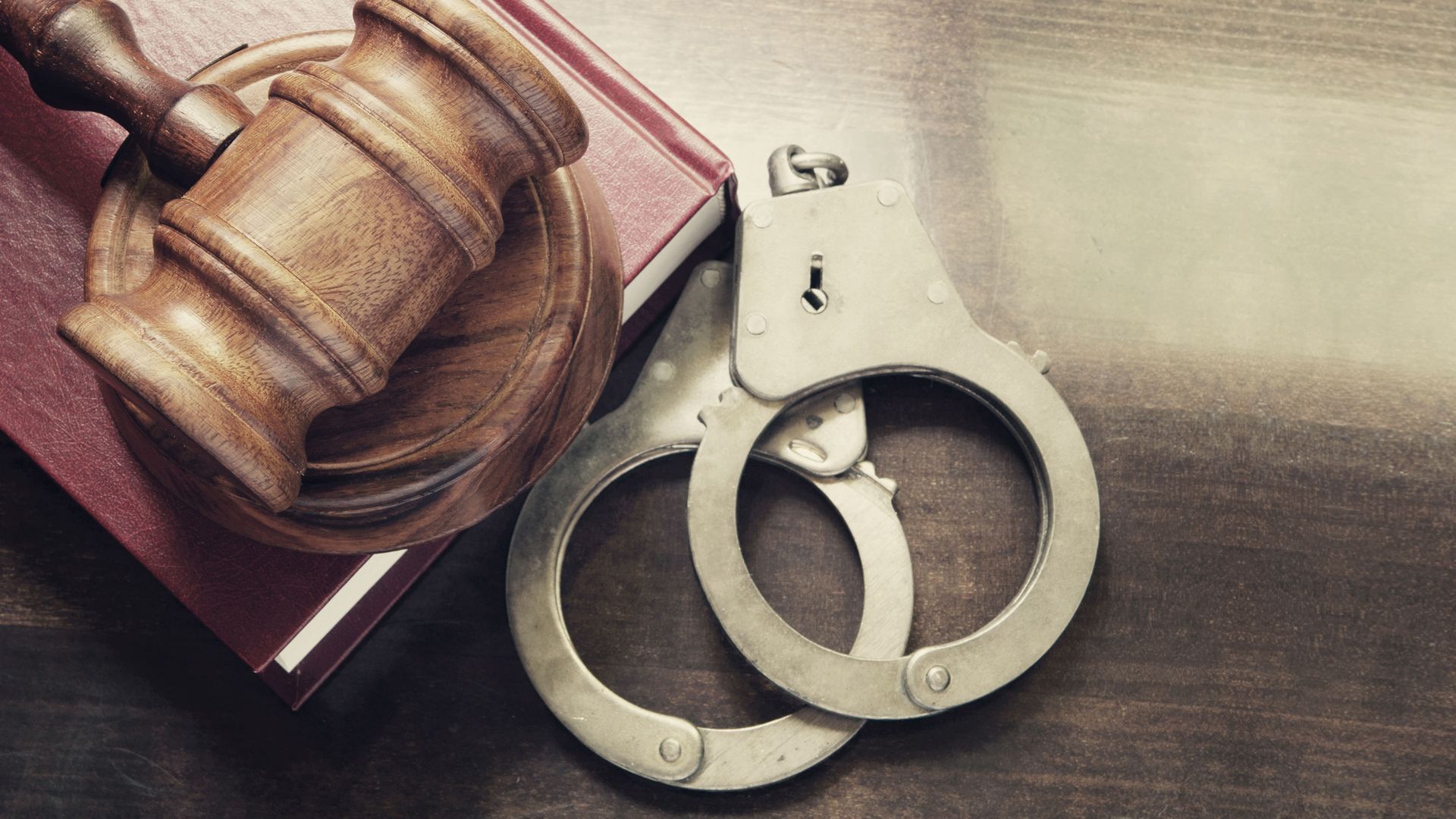A pair of handcuffs and a wooden judge's gavel