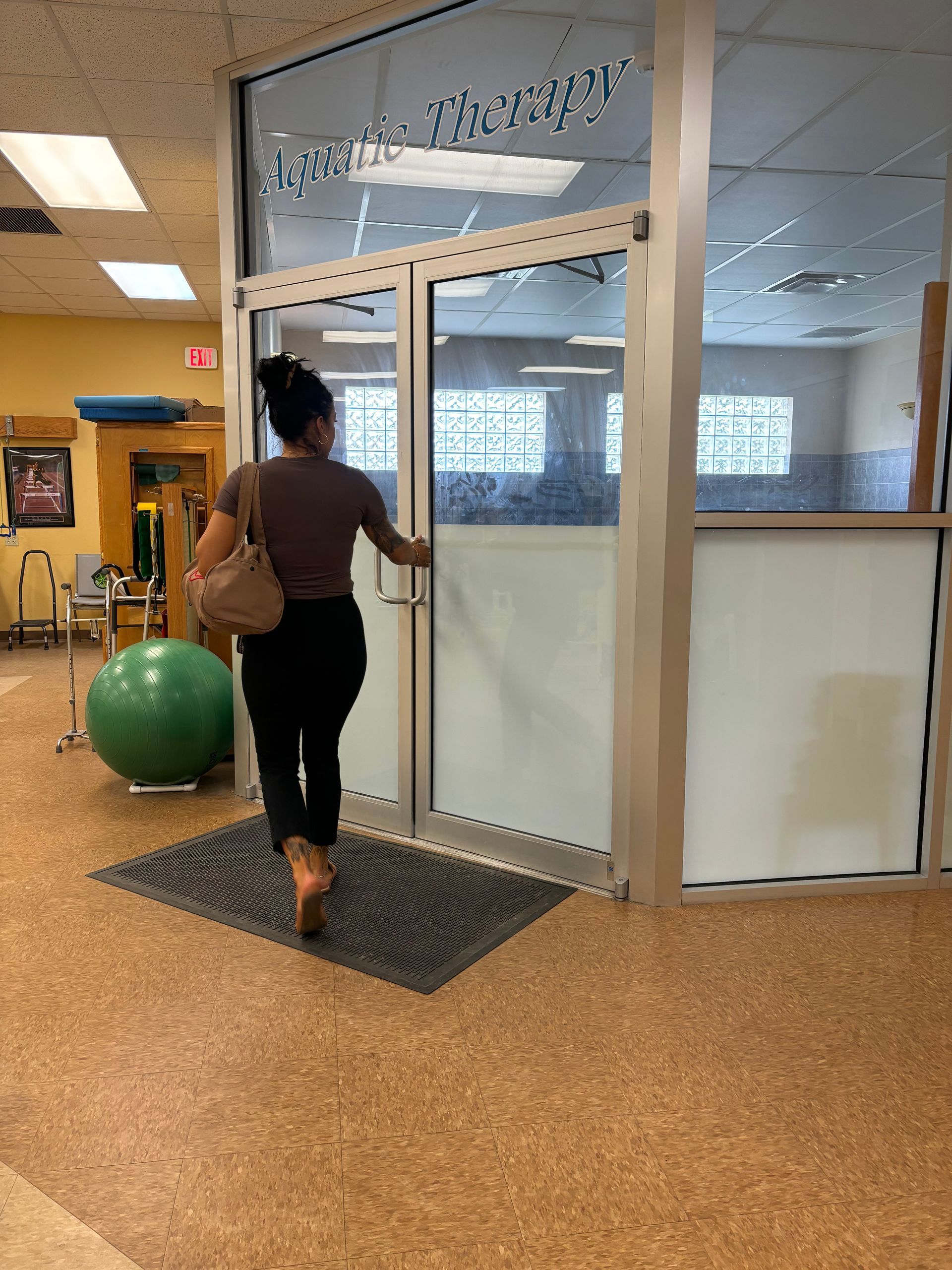 A woman is walking through a doorway in a gym.
