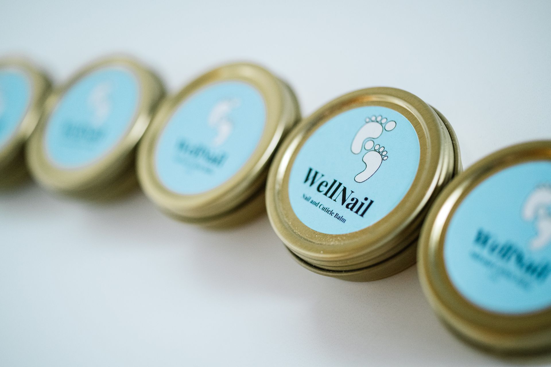 Row of gold-lidded tins with blue labels. The labels say 