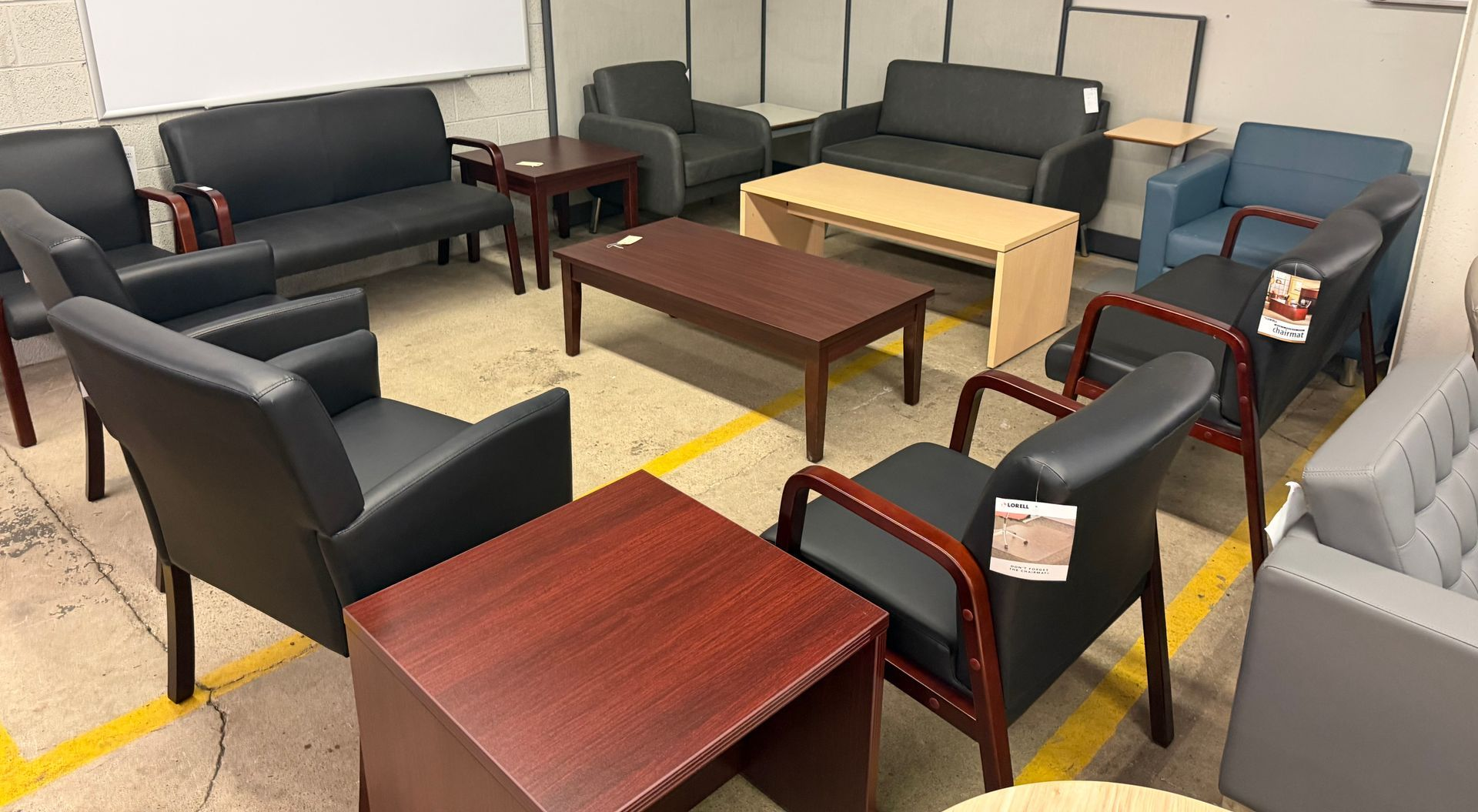 Furniture showroom with black armchairs, wooden tables, and sofas