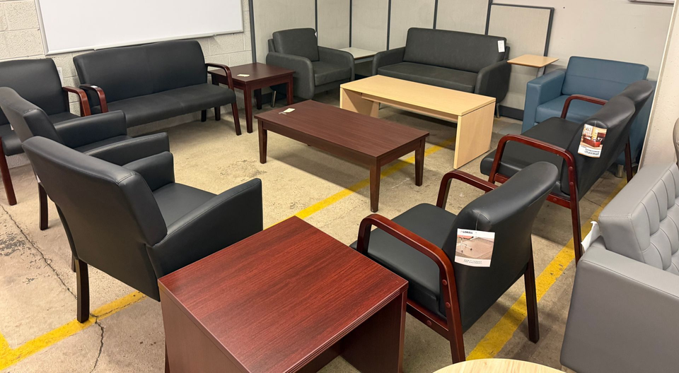 Furniture showroom with black armchairs, wooden tables, and sofas
