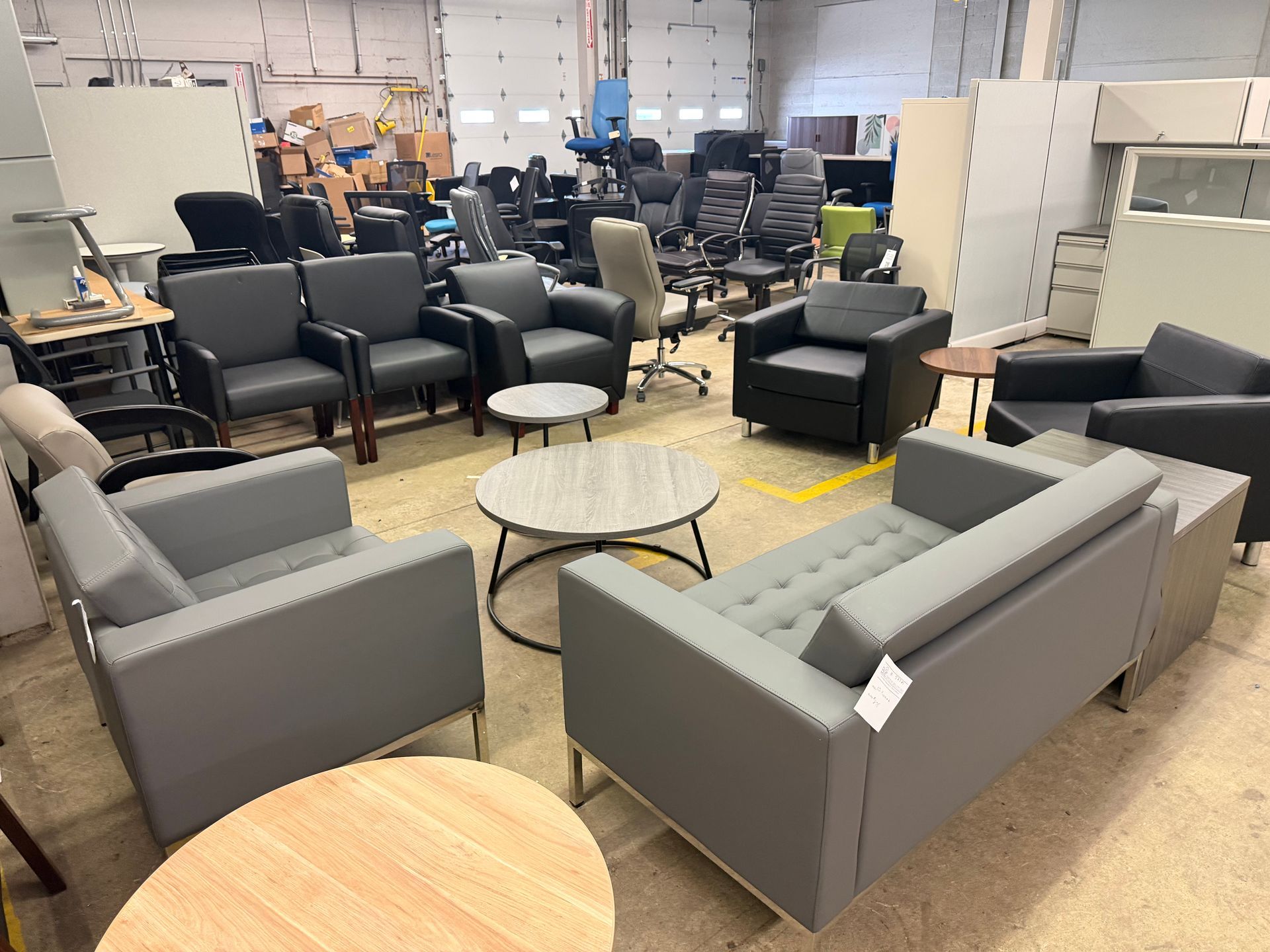 Furniture showroom with gray sofas, chairs, and coffee tables arranged in rows
