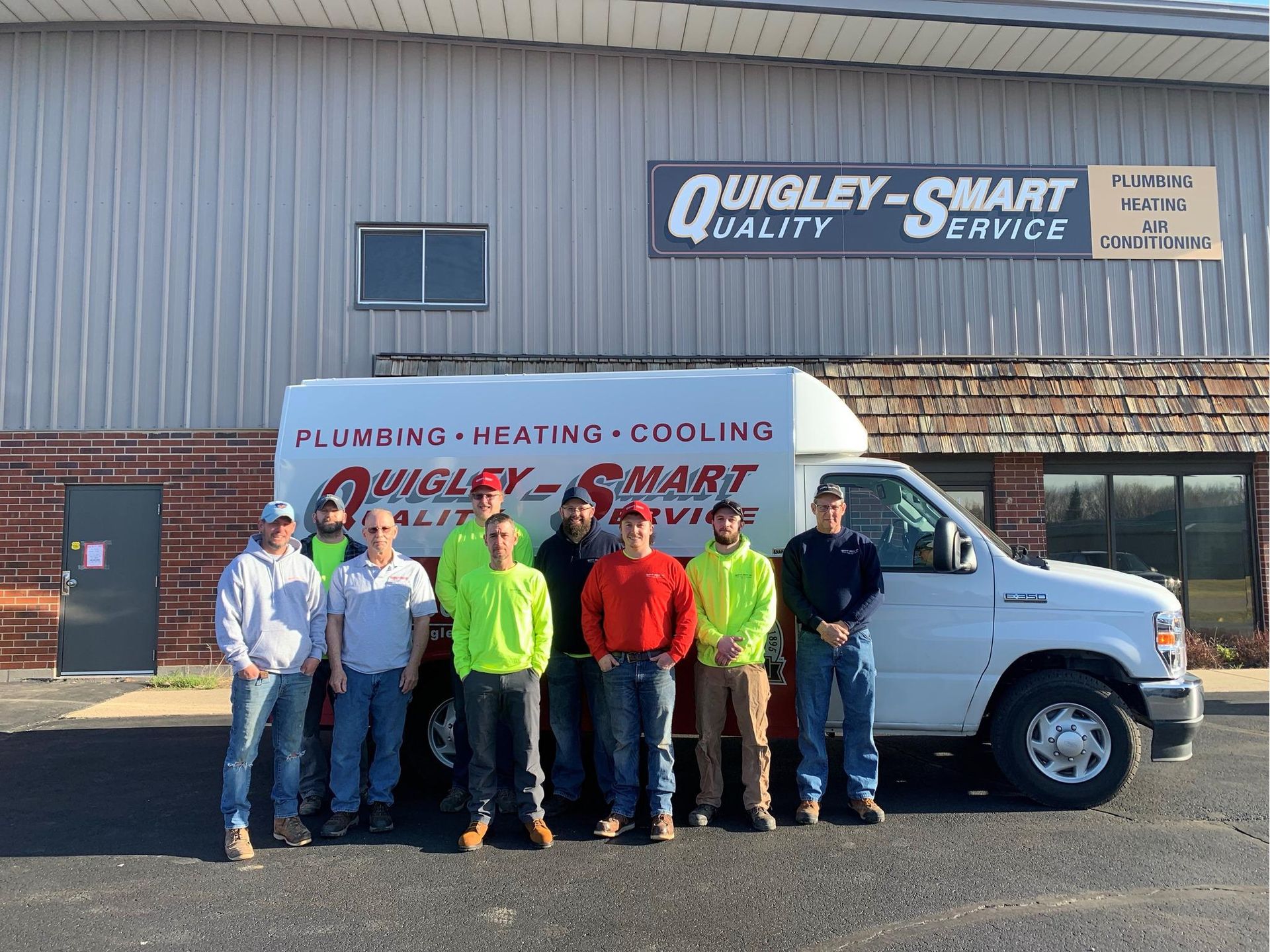 A group of men are standing in front of a white van.