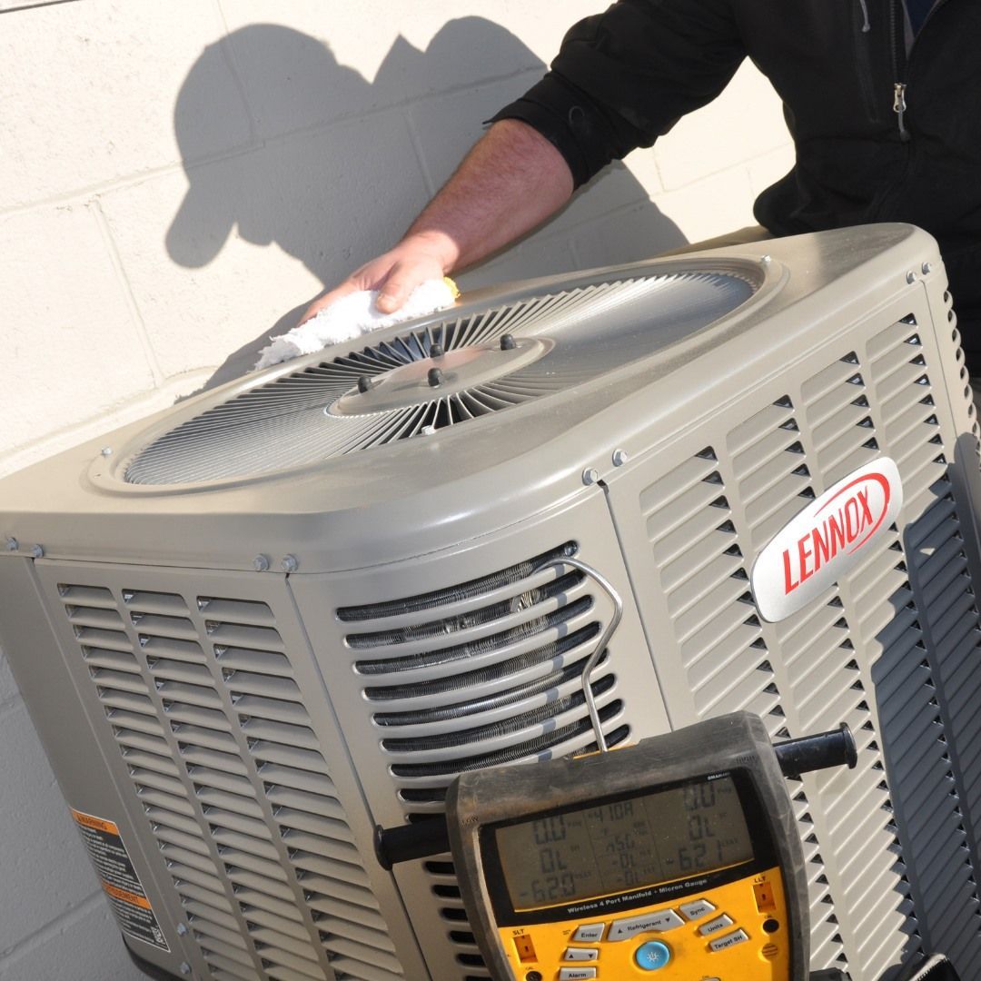 A man is working on a lennox air conditioner.