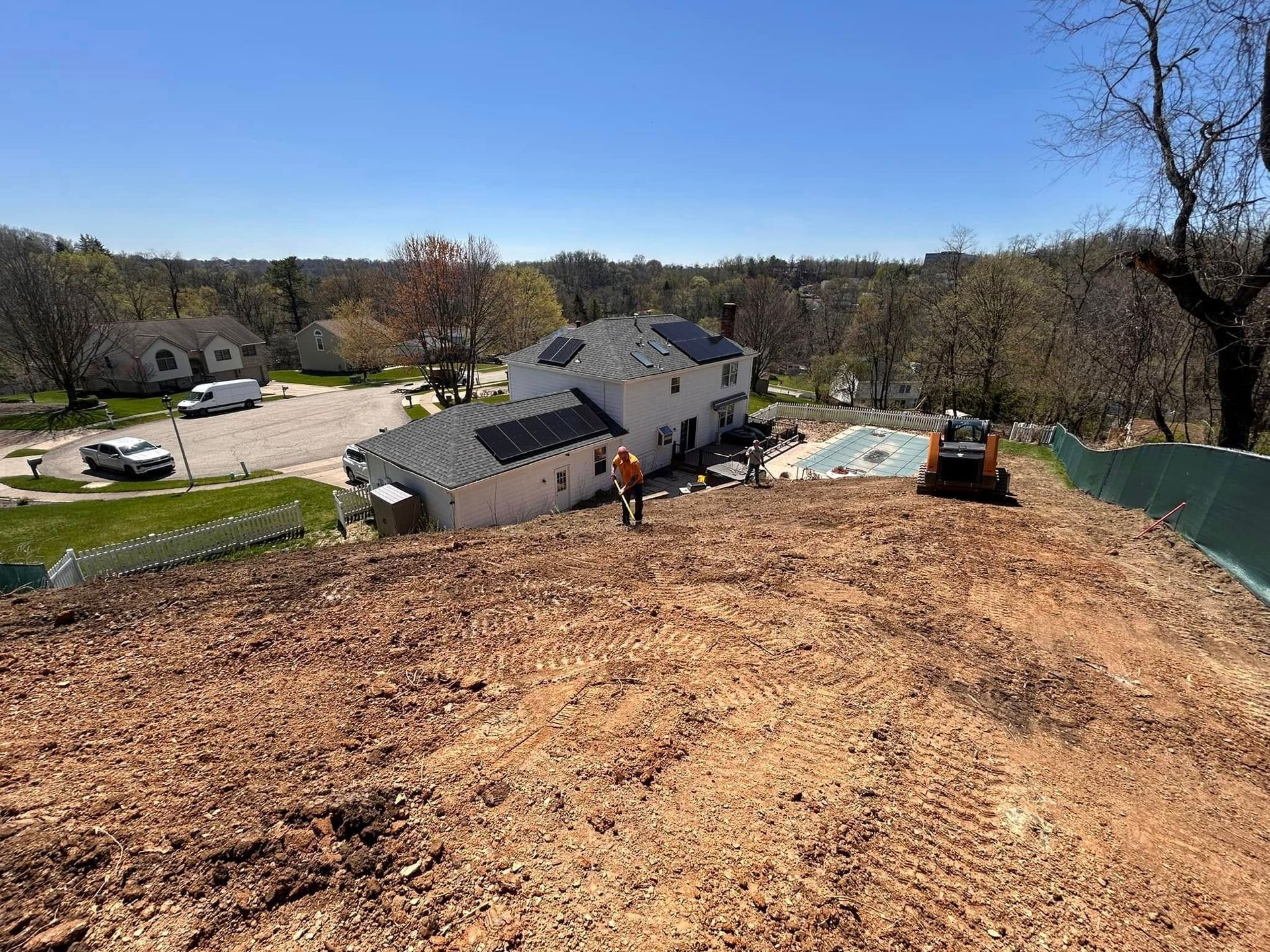 Roof under construction overlooking a suburban neighborhood on a sunny day