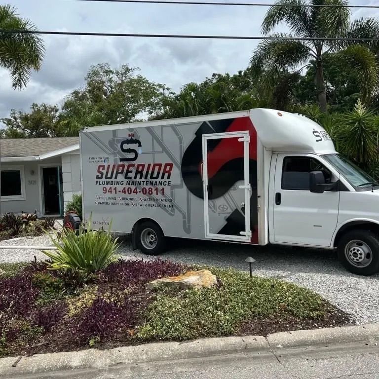 White Superior Plumbing truck parked in front of a house.