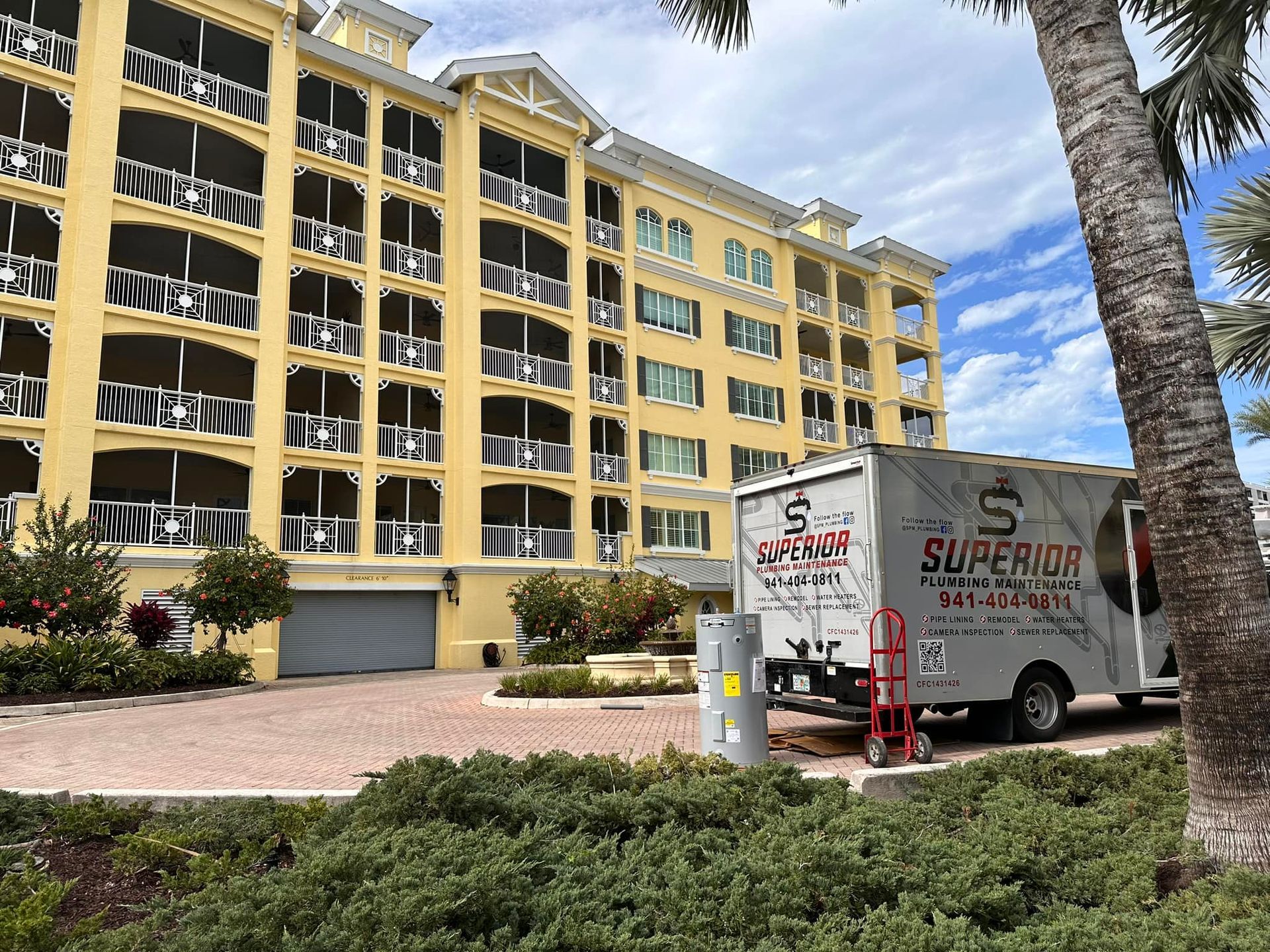 Moving truck parked in front of a yellow apartment building.