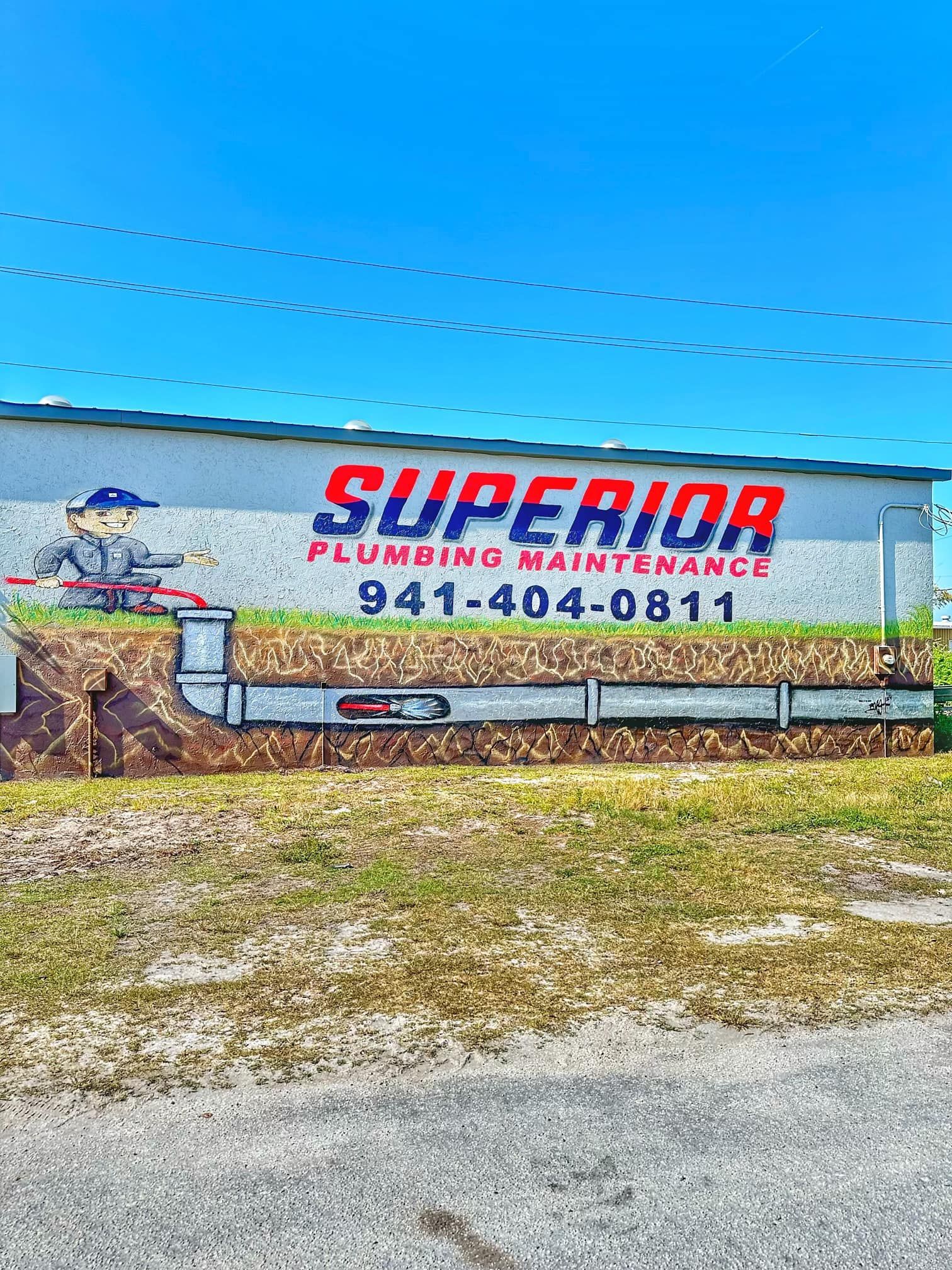 Sign for Superior Plumbing Maintenance with cartoon plumber and phone number 941-404-0811.