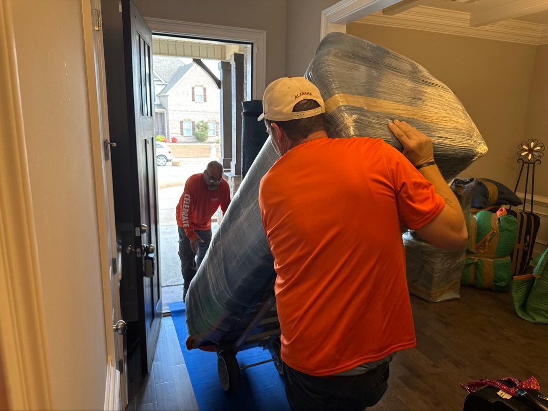 People carrying a large furniture through a doorway into a home