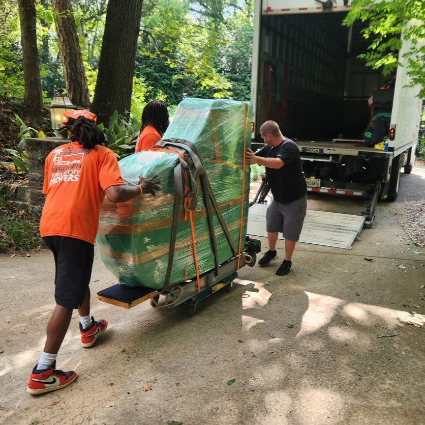 Movers loading a wrapped appliance onto a truck
