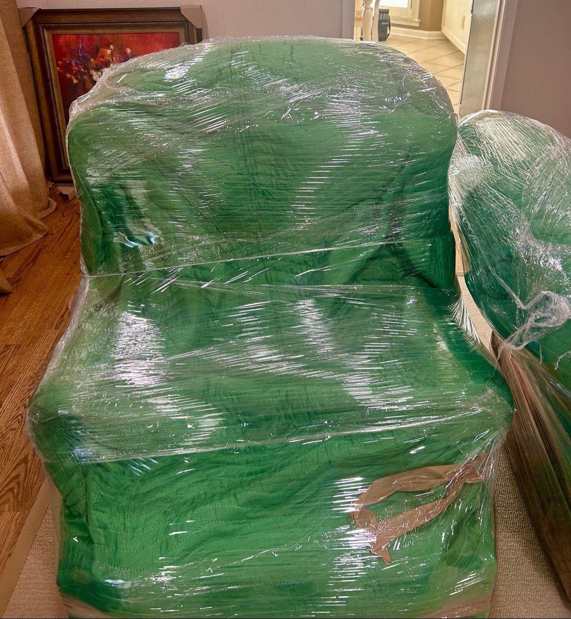 Green chair wrapped in plastic moving wrap